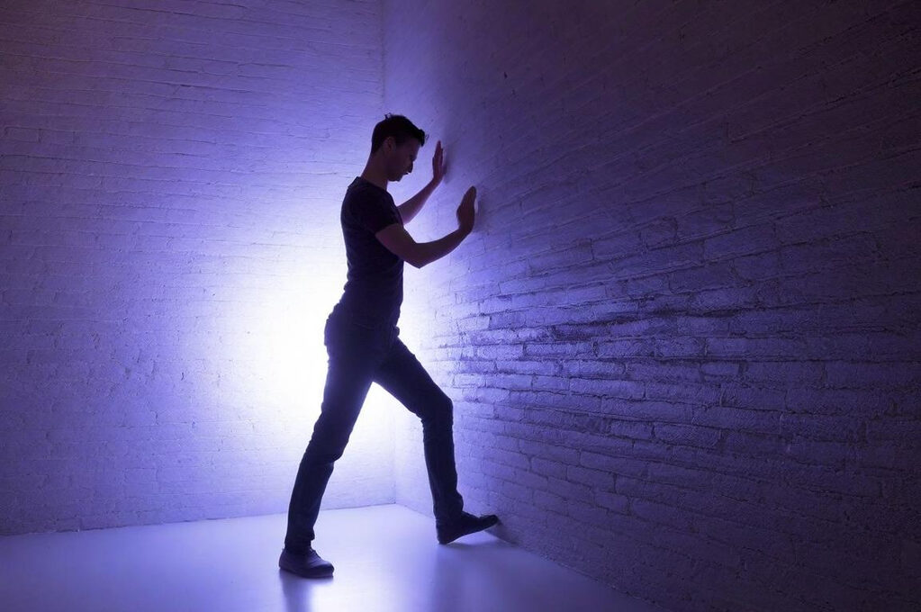 Man pushing at a wall attempting to move resistance