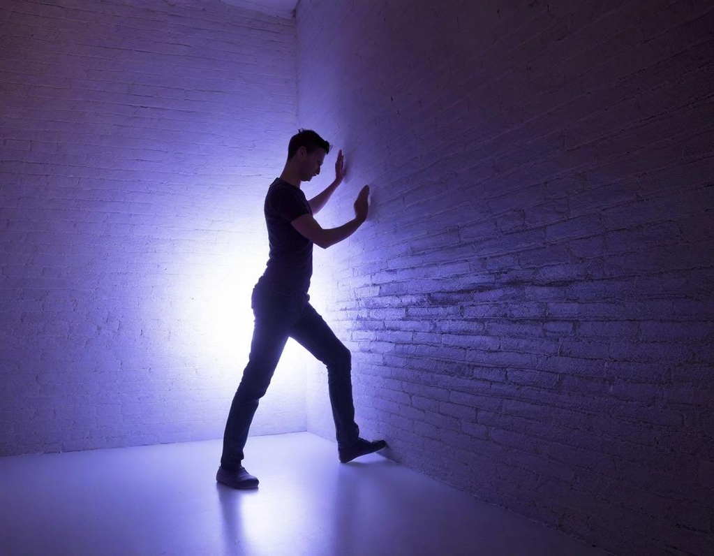 Man pushing at a wall attempting to move resistance